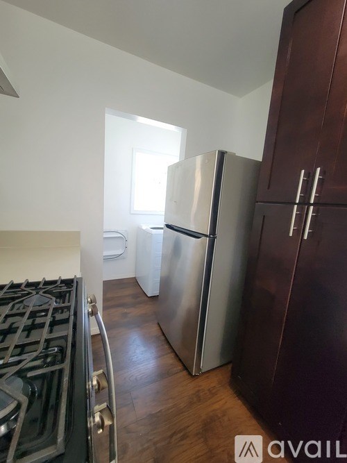 A kitchen with a stove, refrigerator, and cabinets.