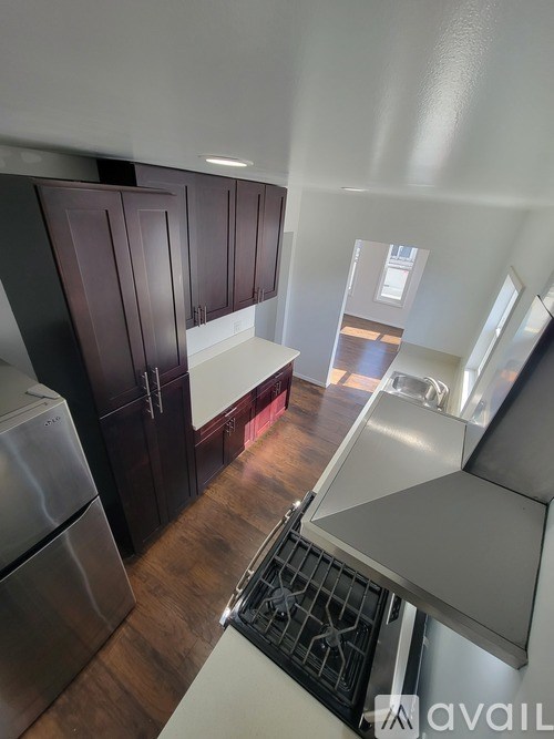 A kitchen with dark wood cabinets and stainless steel appliances.