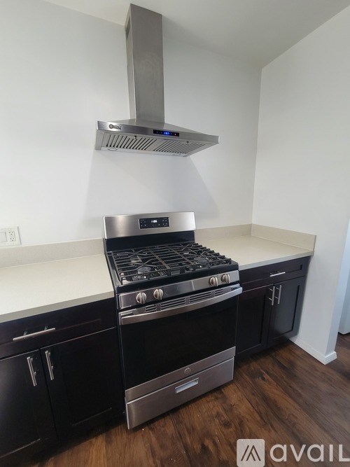 A modern kitchen with a stove and a range hood.