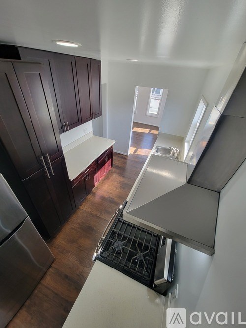 A kitchen with dark wood cabinets and stainless steel appliances.