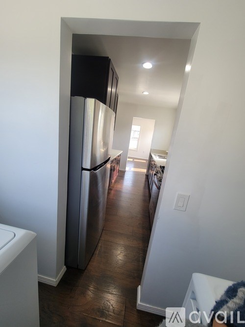 A kitchen with a white fridge and a white wall.