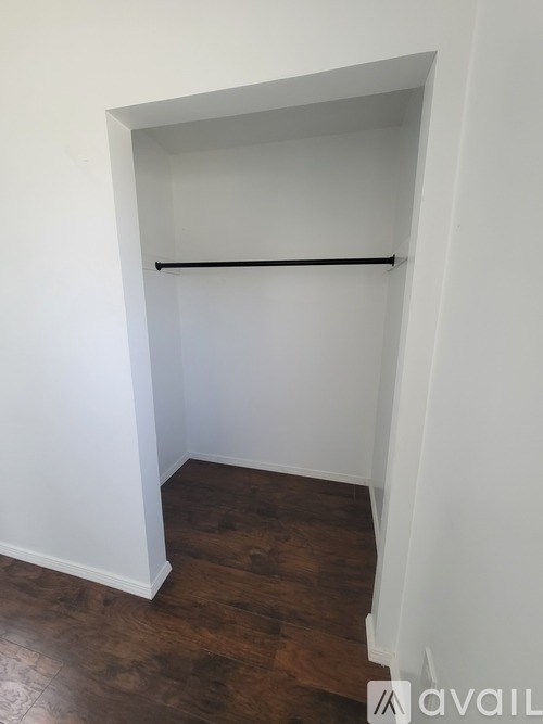 A room with a white wall and a black shelf.