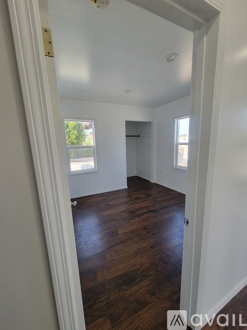 A room with white walls and wooden floors is shown.