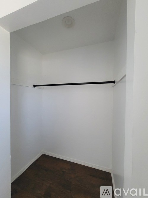 A white wall with a black bar and wooden floor.