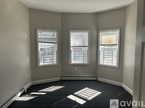 A room with two windows and a carpeted floor.