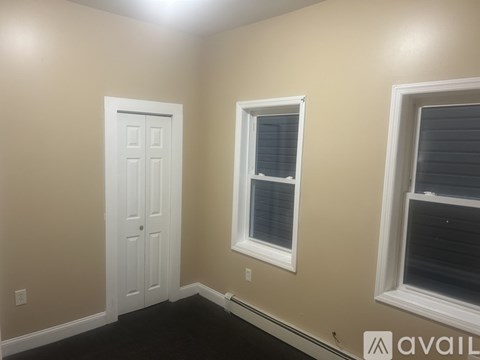 A room with a white door and two windows.