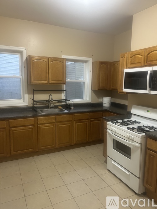 A kitchen with wooden cabinets and a white stove top oven.
