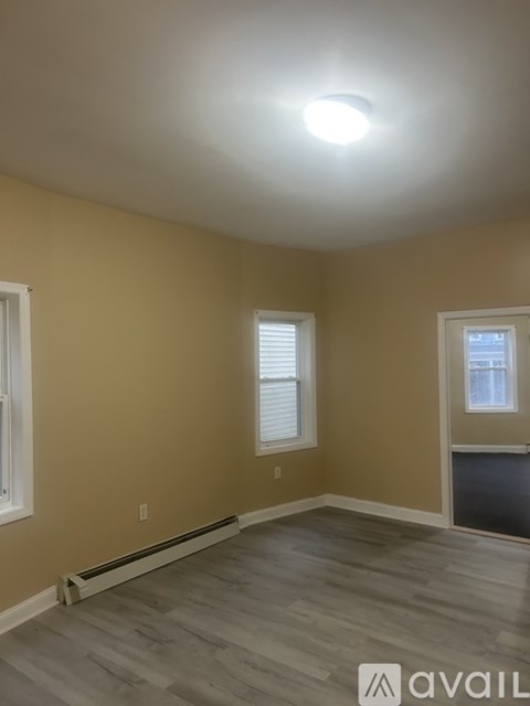 A room with a window and a wooden floor.