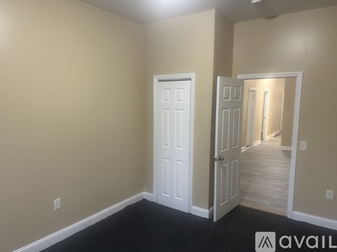 A room with a white door and a black floor.