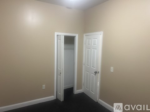 A room with two white doors and beige walls.