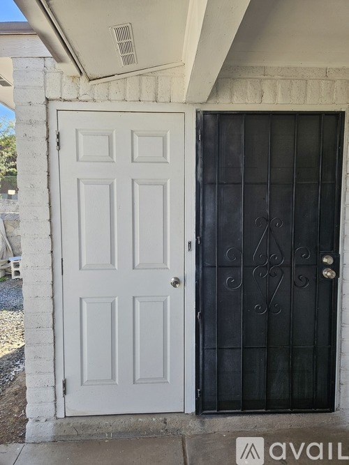 A white door with a black gate and a silver handle.
