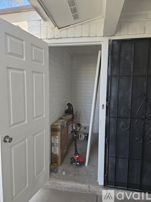 A white door is open to a dark room with a black gate.