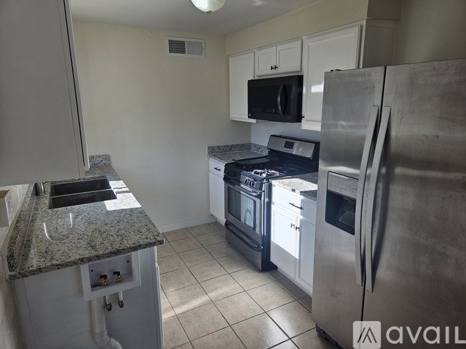 A kitchen with a granite countertop and stainless steel appliances.