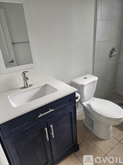 A white toilet sits next to a sink in a bathroom.
