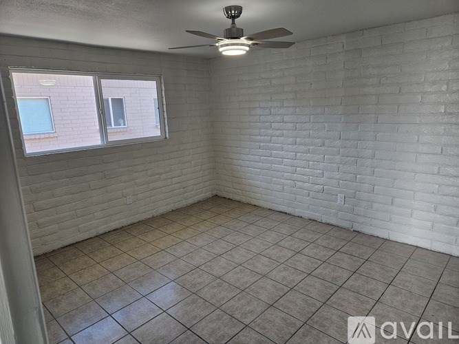 A room with a ceiling fan and tiled floor.