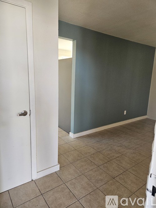 A room with a white door and tiled floor.