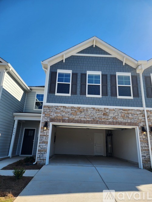 A house with a garage and a stone wall.