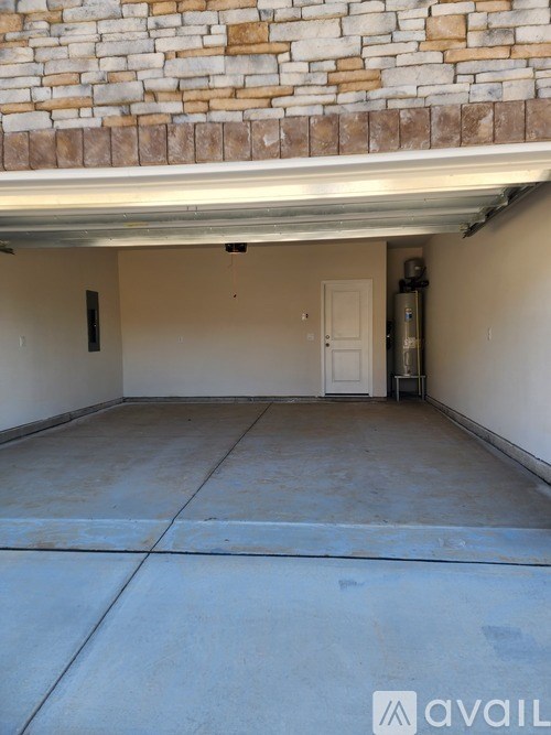 A garage with a white door and a brick wall above it.