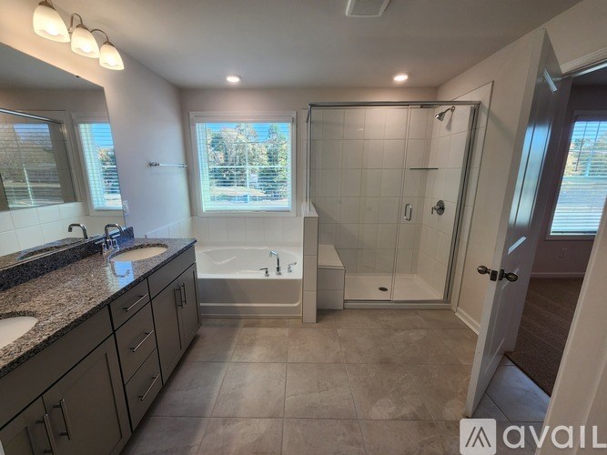 A bathroom with a tub, sink, and shower.