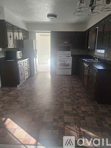 A kitchen with black cabinets and a checkered floor.