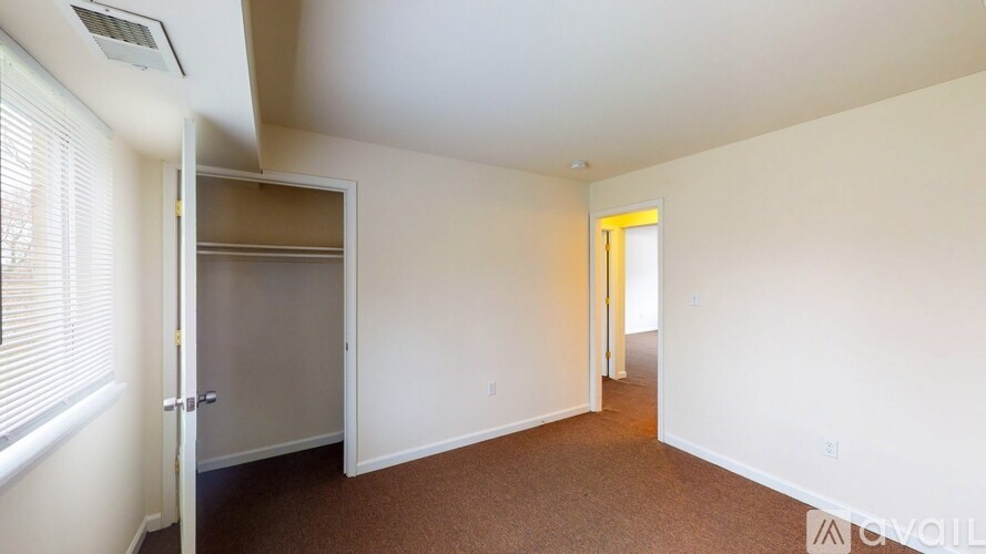 A room with a carpeted floor and a white wall.
