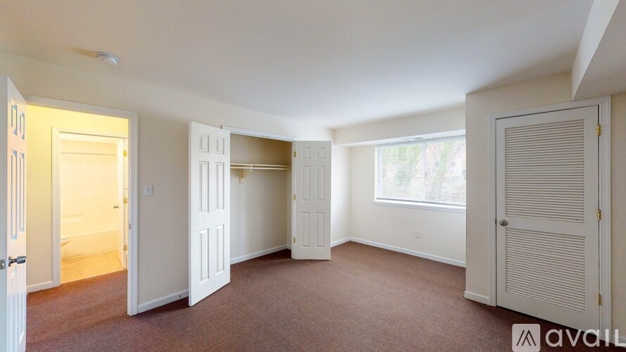 A room with white doors and a carpeted floor.