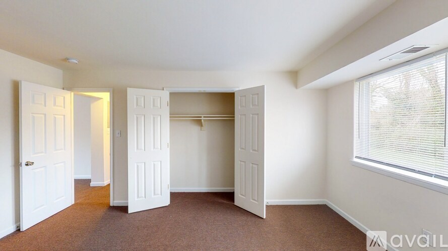 A room with white doors and a window with blinds.