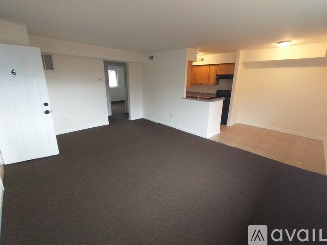 A room with a white door and a white fridge in it.