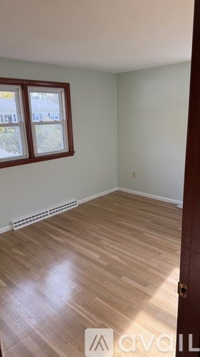 A room with wooden flooring and a window.