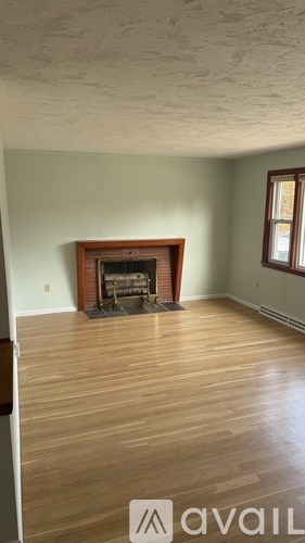 A room with a fireplace and wooden floors.