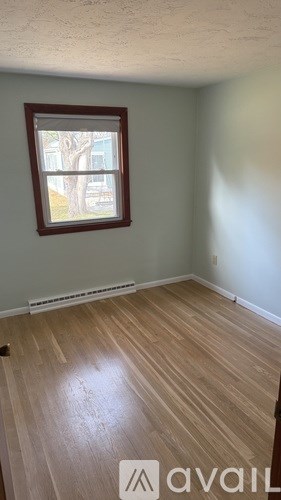 A room with a window and wooden flooring.