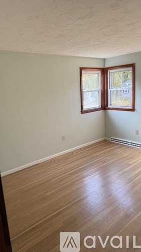 A room with wooden flooring and a window.