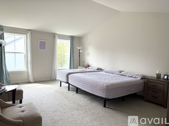 A bedroom with a large bed and a chair.