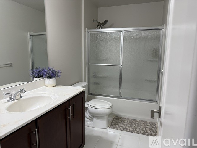 A bathroom with a toilet, sink, and shower.
