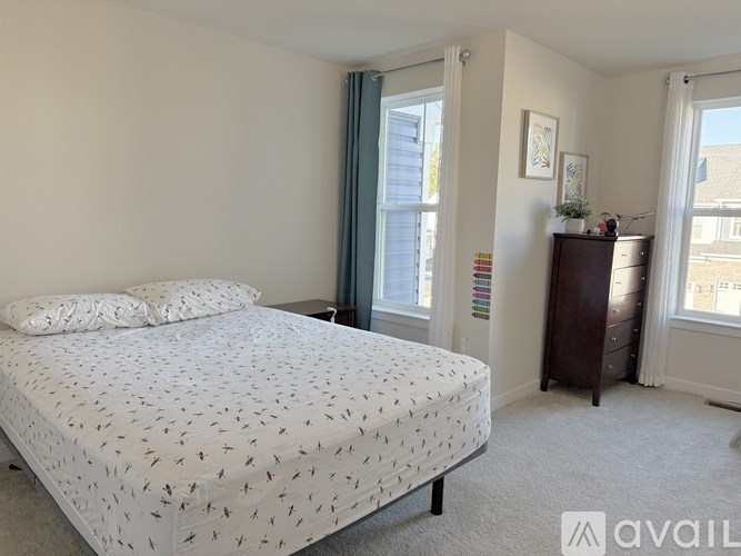 A bedroom with a bed, nightstand, and window.