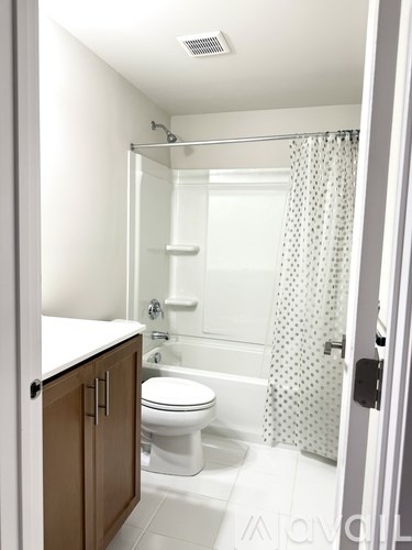 A white bathroom with a toilet, sink, and shower.