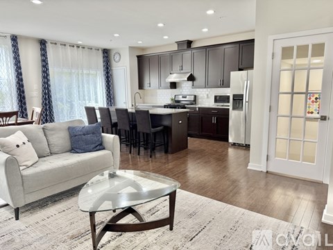 A modern kitchen with dark brown cabinets and a white island.