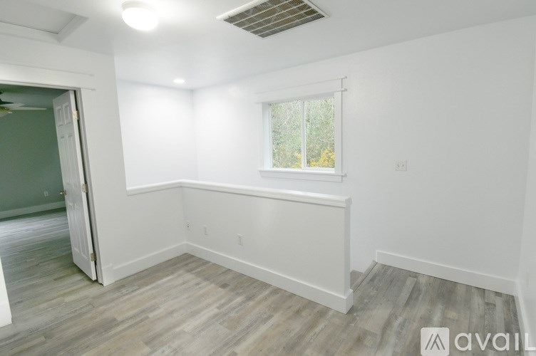 A room with a window and a door leading to another room.