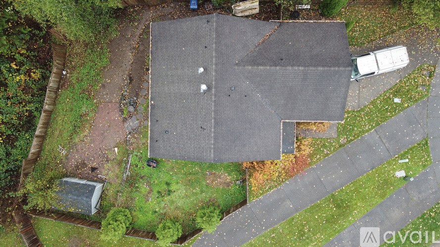 A large grey building with a white van parked in front.