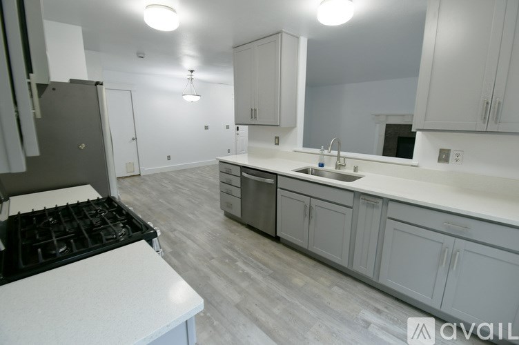 A kitchen with white cabinets and a black stove top.