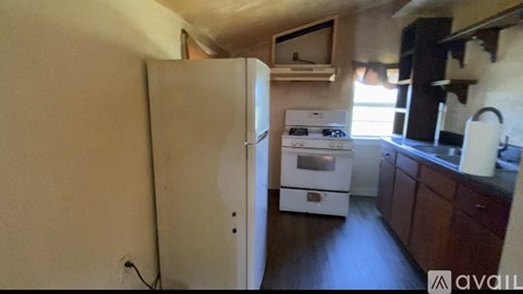 A kitchen with a white refrigerator and wooden cabinets.
