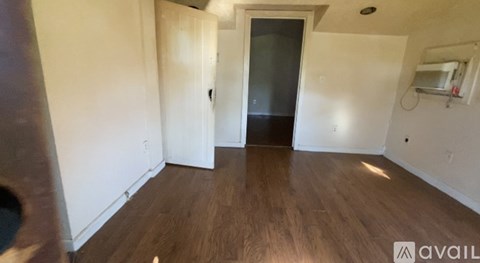 A room with wooden flooring and a white door.