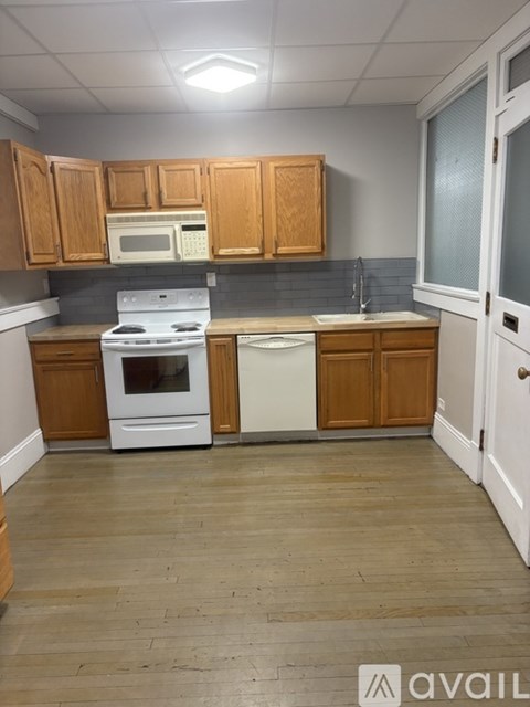 A kitchen with wooden cabinets and a white stove top oven.
