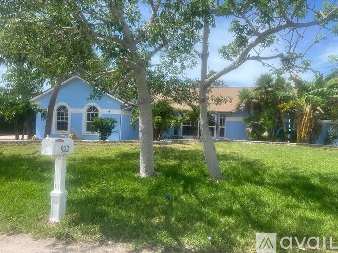 A blue house with a white mailbox in front of it.