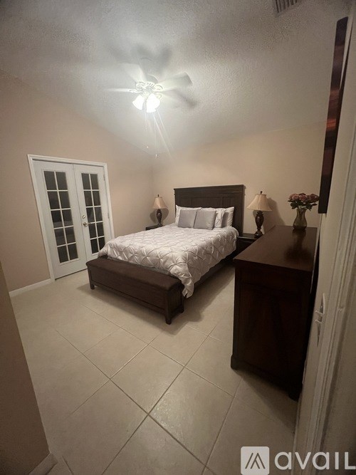 A bedroom with a bed, nightstand, and window.