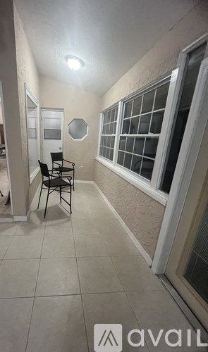 A room with a chair and a window.