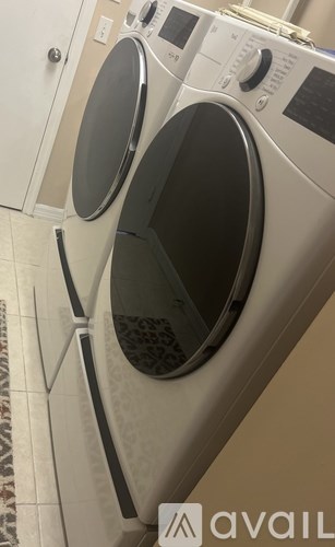 A white front loading washing machine with a black control panel.