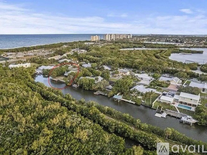 A bird's eye view of a coastal area with houses and a body of water.
