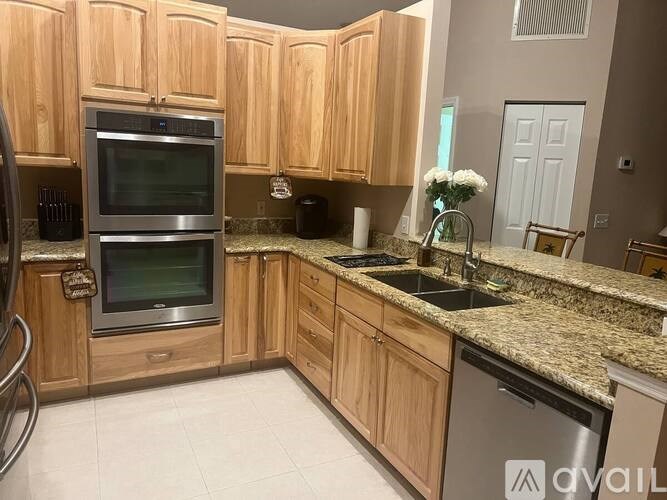 A kitchen with wooden cabinets and granite countertops.