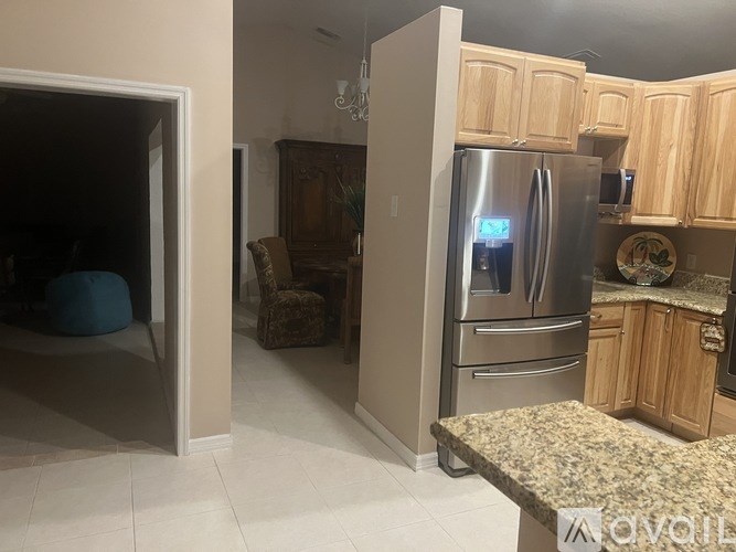 A kitchen with a refrigerator, oven, and cabinets.